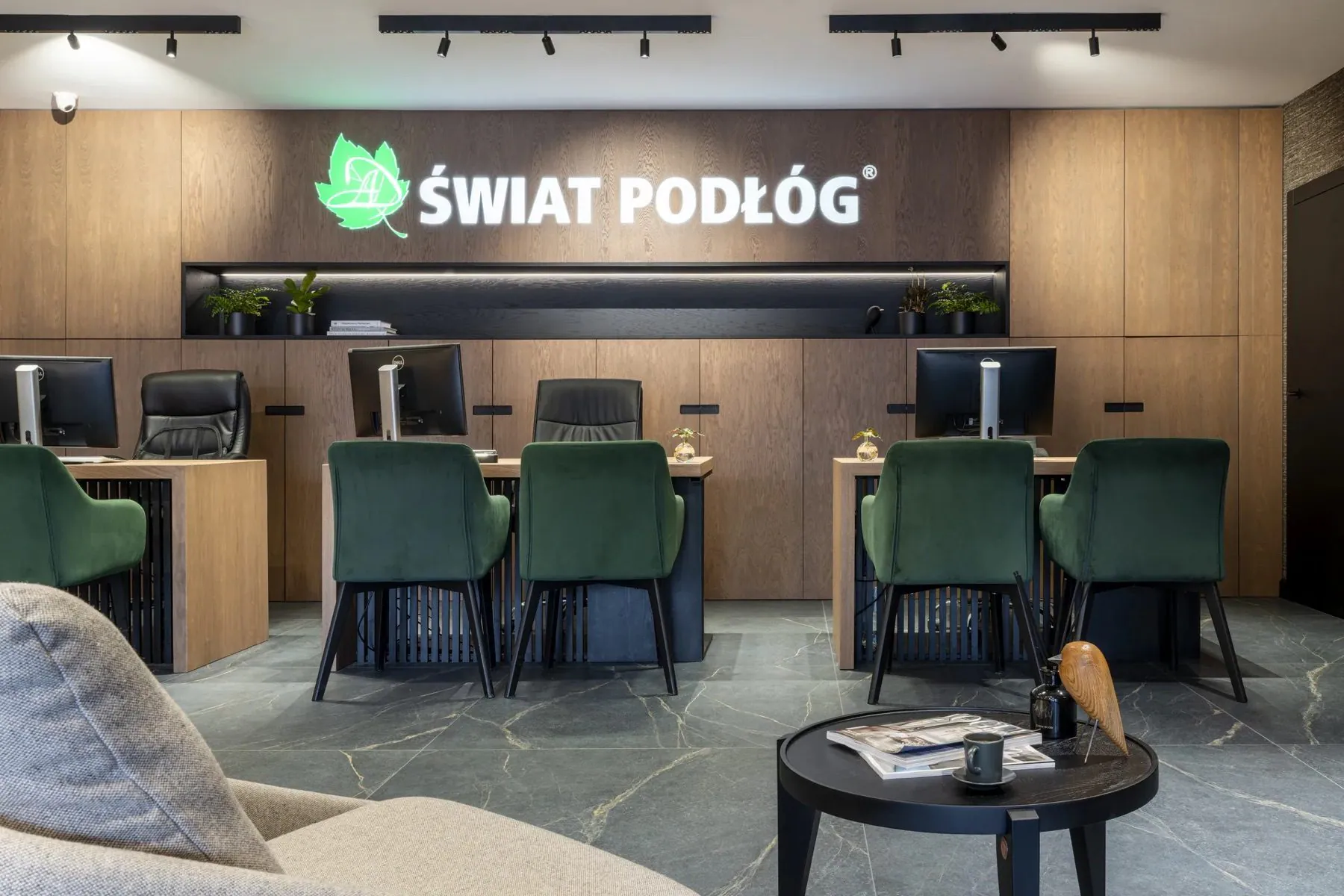 Stanowiska doradców w salonie Świat Podłóg z logo marki nad ladą