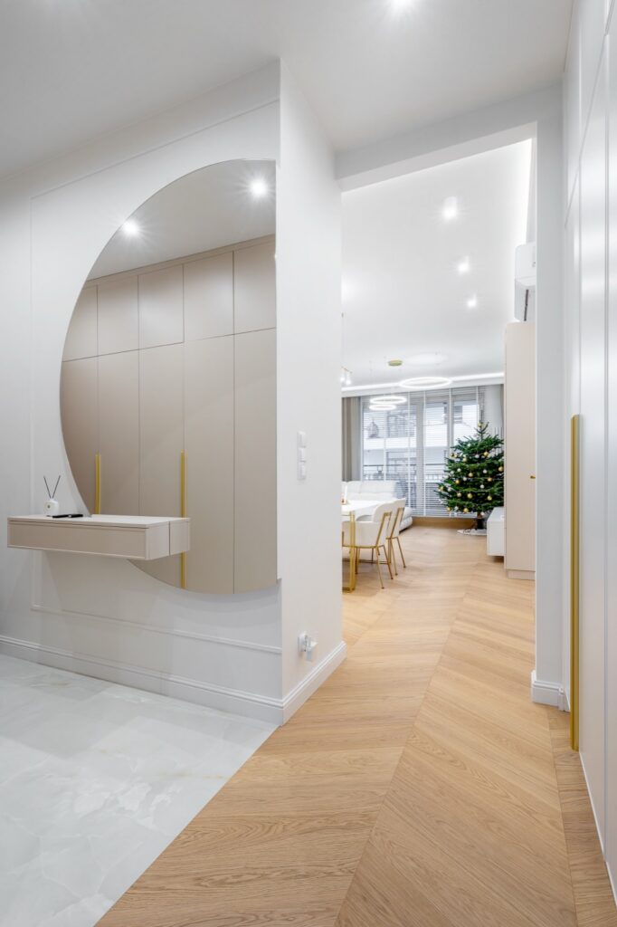 Przedpokój i salon open space z jodełką francuską jasnego dębu